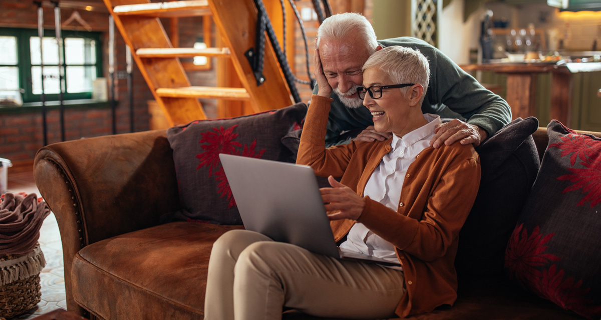 Senior couple reading interesting news on their laptop